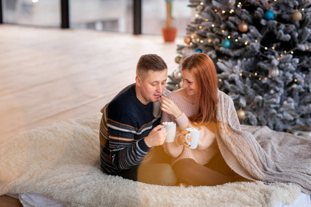 一对幸福的夫妇在圣诞树旁玩得开心