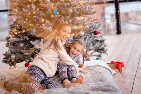 快乐的孩子们在圣诞树附近玩得开心