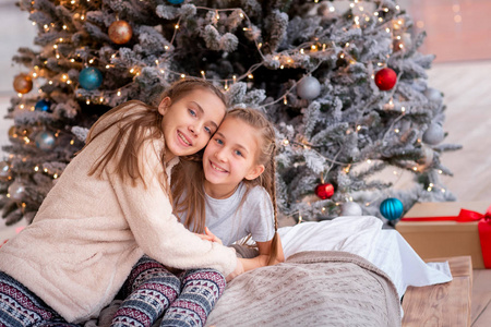 快乐的孩子们在圣诞树附近玩得开心