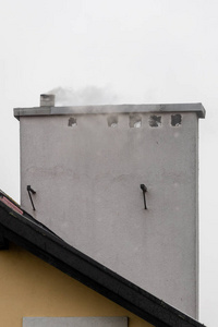 Smoke rising from the chimney in a singlefamily house. 