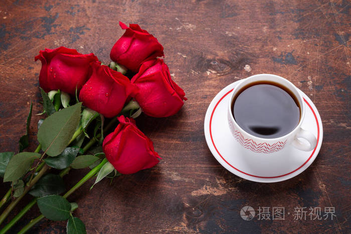 木质背景上的红玫瑰花束和咖啡杯情人节贺卡复制空间俯视图