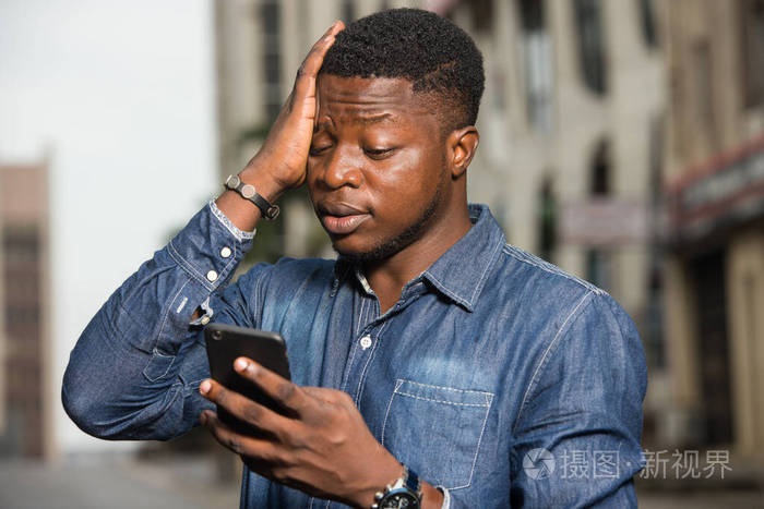 一个拿着手机的非洲年轻人的特写镜头