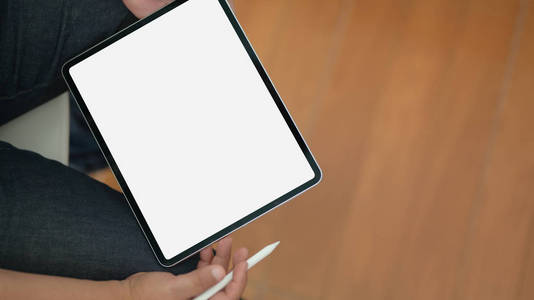 Closeup view of man using blank screen digital tablet while sit