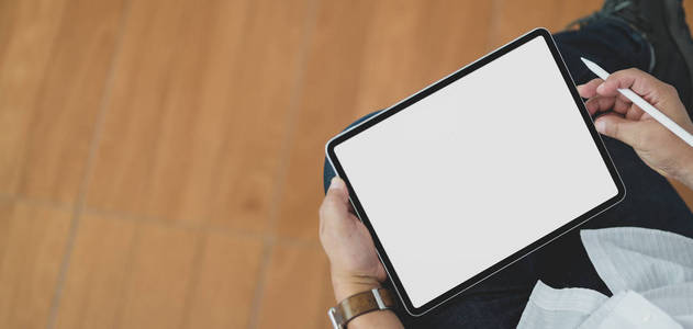 Closeup view of man using blank screen digital tablet while sit