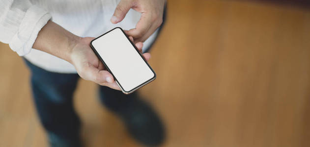 Closeup view of man using blank screen smartphone while standin