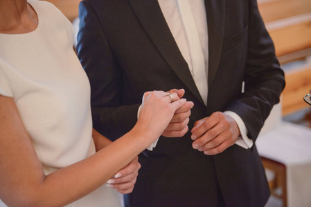 新娘和新郎在婚礼上把结婚戒指戴在手指上