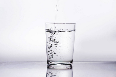 蓝色游泳中干净水波纹图案的背景一个装有干净纯净水和冰块的玻璃杯.