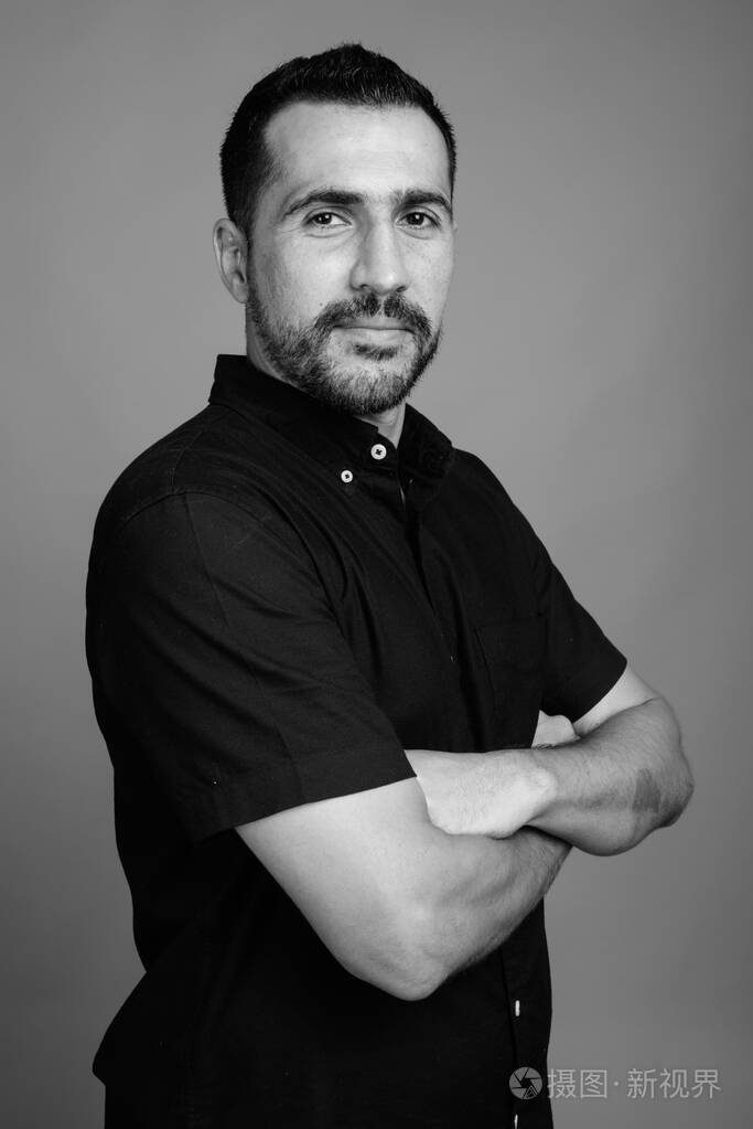 灰色背景下英俊的大胡子波斯男人