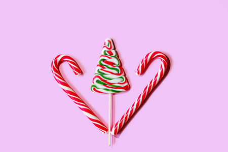 粉红色背景上糖果做成的圣诞树。最小创意概念。