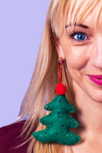 Beautiful girl with earring in the shape of a Christmas tree in 