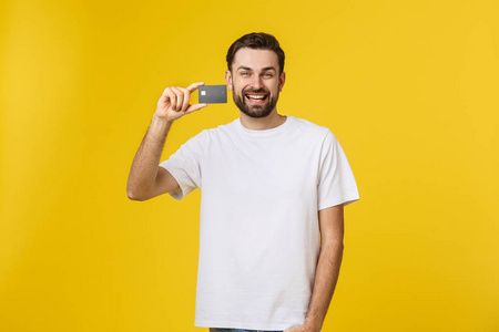 笑容可掬的年轻人在黄色背景上展示信用卡