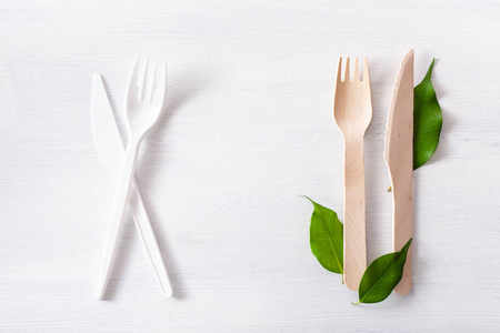 有害塑料餐具和环保木制餐具。塑料