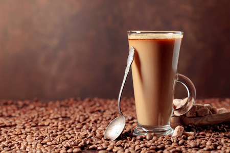  Coffee latte and brown sugar on a table with coffee beans. 