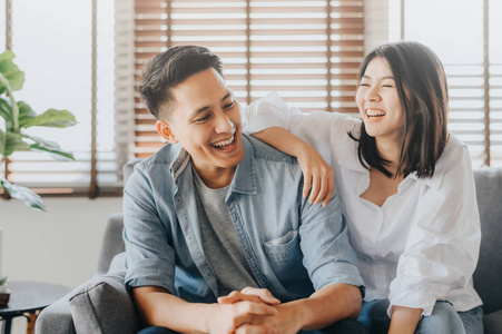 Asian couple having fun and laughing in loving room 