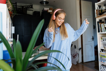小女孩在公寓用耳机听音乐的画面