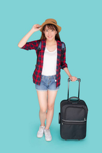 美丽的年轻亚洲女人拉着蓝巴隔离的手提箱