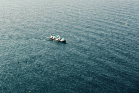 一艘船在海湾的蓝色海面上航行图片