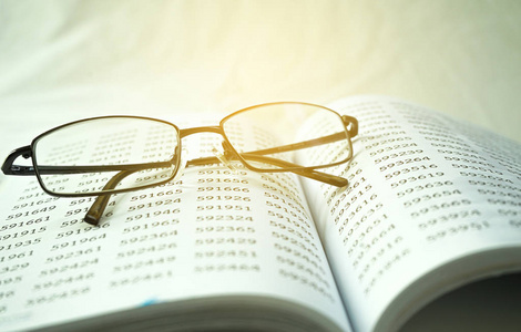 Old math books on blankets with glasses 