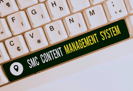 显示Smc内容管理系统的文本标志。概念图片分析创建和修改后的白色电脑键盘与空白笔记纸以上的白色背景键复制空间。