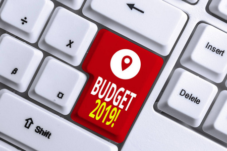 说明2019年预算的书面说明。商业照片显示当年收入和支出的预算，白色电脑键盘上方有便笺。