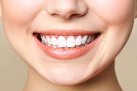年轻女人完美健康的牙齿微笑.牙齿美白.牙科门诊病人.