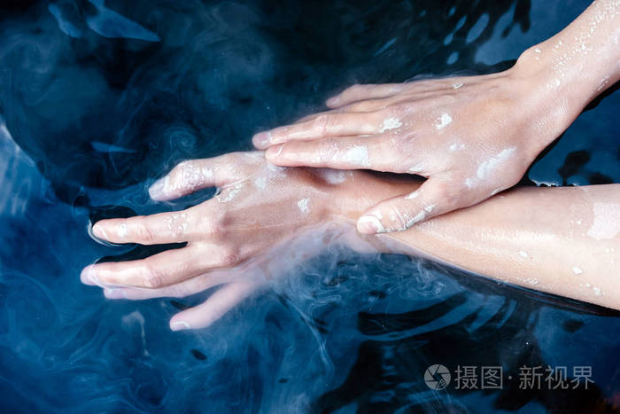 一双优雅的女性手放在水里的干粘土里