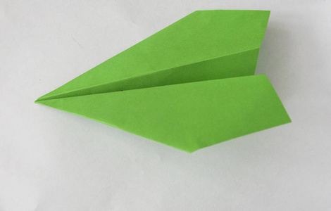 green paper plane on white background. 