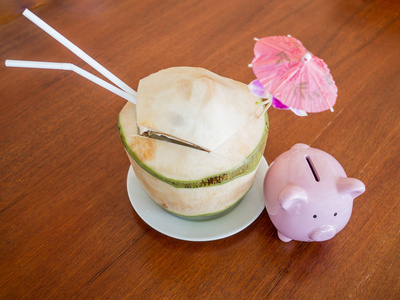 粉红色的小猪存钱罐，椰子饮料，假日消费储蓄和退休基金概念