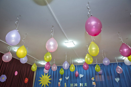 粉红色和黄色的气球漂浮在房间里的白色天花板上。婚礼或儿童生日派对装饰内饰。氦气球。