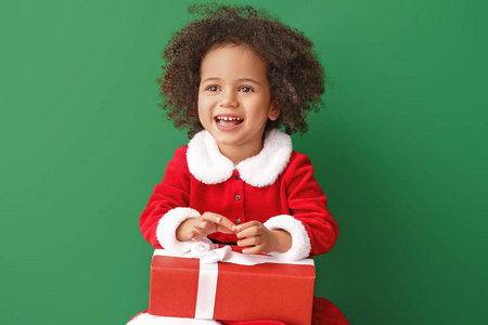 美国黑人小女孩，身着圣诞老人服装，彩色背景上有礼物