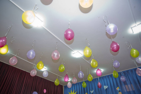 粉红色和黄色的气球漂浮在房间里的白色天花板上。婚礼或儿童生日派对装饰内饰。氦气球。