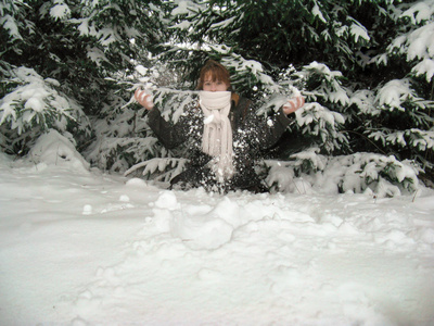 女孩在冬日冷杉下的雪堆里洗澡图片