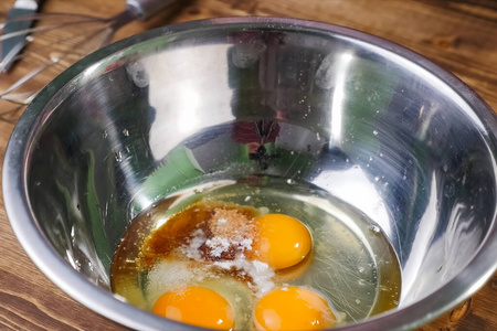 金属杯里的生鸡蛋。打鸡蛋。