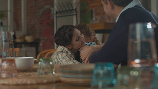 Family lunch, happy mother hugs her daughter greatfully 