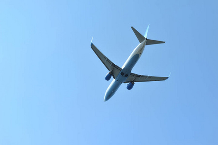 这架客机在蓝天的背景下低空飞行。底视图