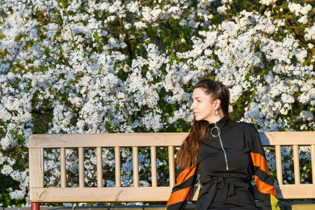 girl on the background of a blossoming apple tree. in black clot