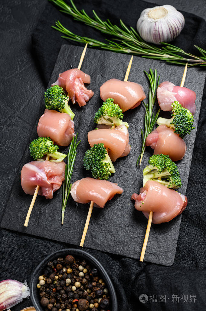新鲜生鸡肉串黑色背景俯视图