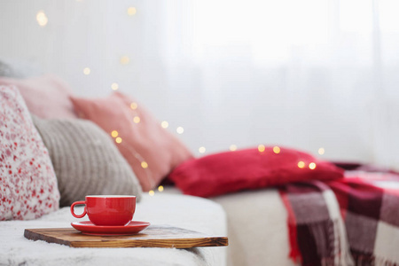 cup of tea on wooden tray on sofa 