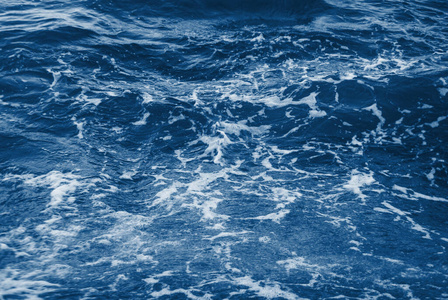 纯净海水背景为白色泡沫的蓝色海水.照片