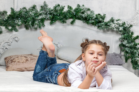 可爱漂亮的小女孩趴在布鲁的床上照片