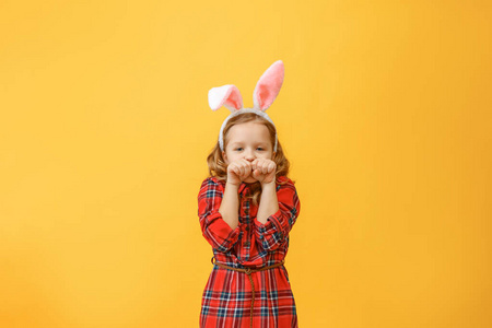一个快乐的小女孩，画着兔子耳朵。复活节快乐