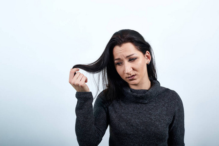 失望的女人用手抓着头发，理了理头发，看起来很困惑