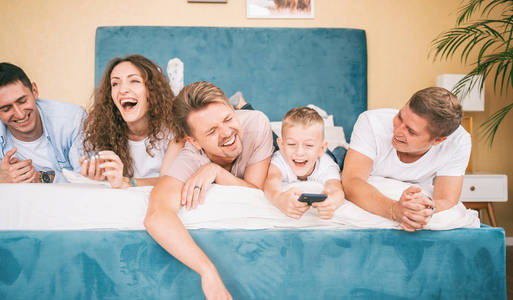 Happy and joyful people company of friends laughing on the bed, 