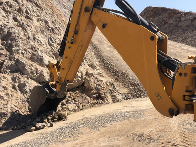 在道路建设工程中，黄色装载机反铲挖沟。运土挖掘在岩石土壤上挖掘