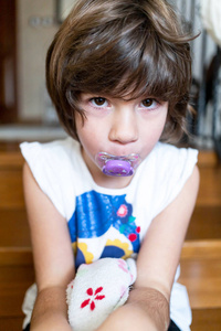 叼女孩一个皮肤黝黑的小女孩,嘴里叼着奶嘴.长大的孩子,习惯照片