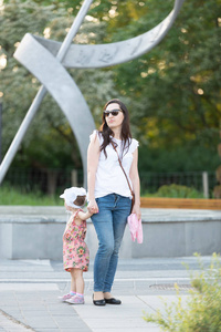 Happy mother and daughter in the park. Beauty nature scene with 