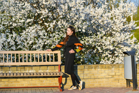 girl on the background of a blossoming apple tree. in black clot