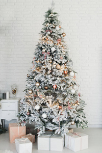 Beautiful glowing white snowcovered Christmas tree in the home 