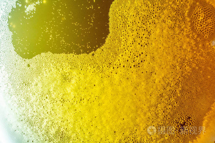背景灯下的玻璃里有气泡的啤酒泡沫在进近中