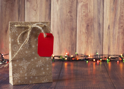 礼物用牛皮纸包装，在木制背景上用缎带系上圣诞风格的花环